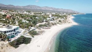 A coastal town with a beach, houses, and mountains in the background. - Casa Torote, La Ventana (El Sargento)