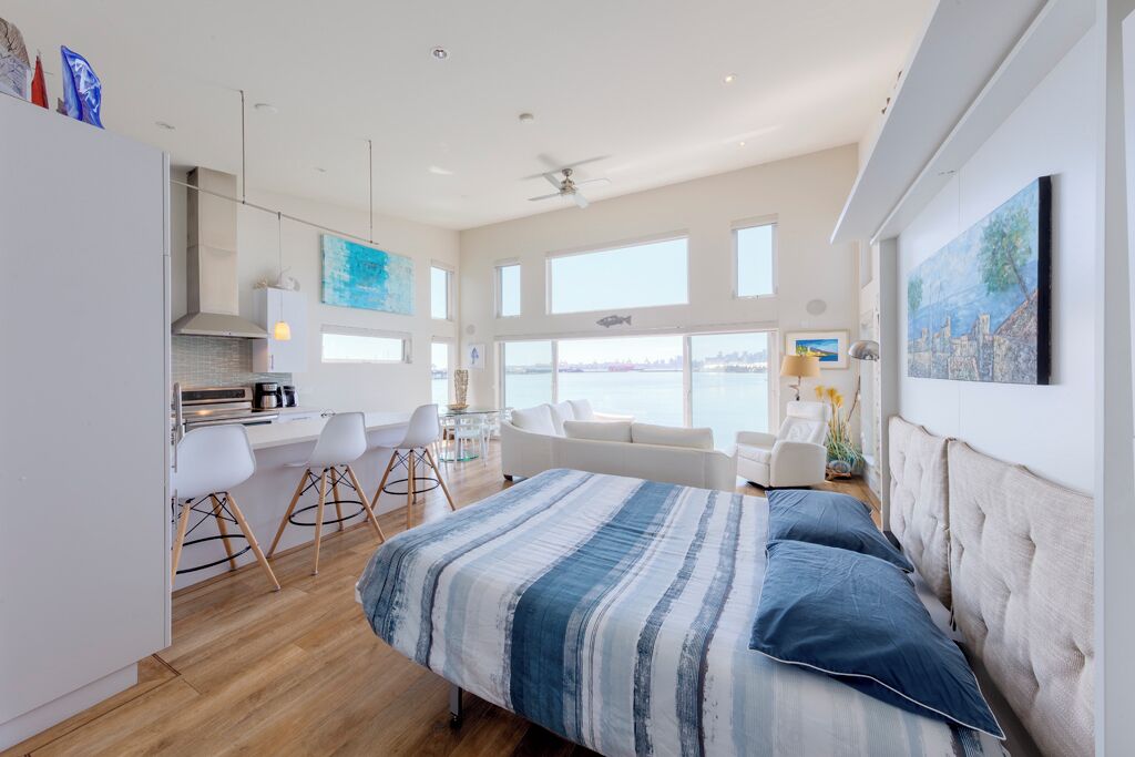 Une chambre moderne avec un lit, un coin repas et une vue sur la mer.