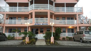 A multi-story building with balconies, a sign reading "Antigua Seawave," and a parking area in front. - Antigua Seaview Alamanda 6 - Affordable, Convenient And Comfortable (St. John's)