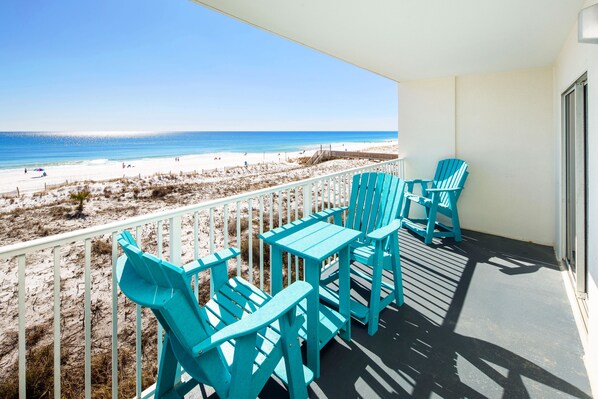 A balcony with turquoise chairs and a table overlooking a beach. - Gulf Dunes 309 • Direct Ocean View from 4th Floor, Beautiful Beach Condo, Free Beach Service (Fort Walton Beach)