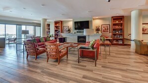 A spacious living area with a fireplace, a television, and a bookshelf. - Rare 4 Bd / 3 Ba 2,900+ Sq ft Oceanfront Luxury Condo w Huge Balcony & Grill (Daytona Beach)