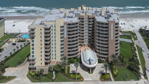 A multi-story hotel with a curved facade, located adjacent to a beach. - Rare 4 Bd / 3 Ba 2,900+ Sq ft Oceanfront Luxury Condo w Huge Balcony & Grill (Daytona Beach)