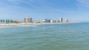 A coastal cityscape with a beach, buildings, and clear skies. - Rare 4 Bd / 3 Ba 2,900+ Sq ft Oceanfront Luxury Condo w Huge Balcony & Grill (Daytona Beach)
