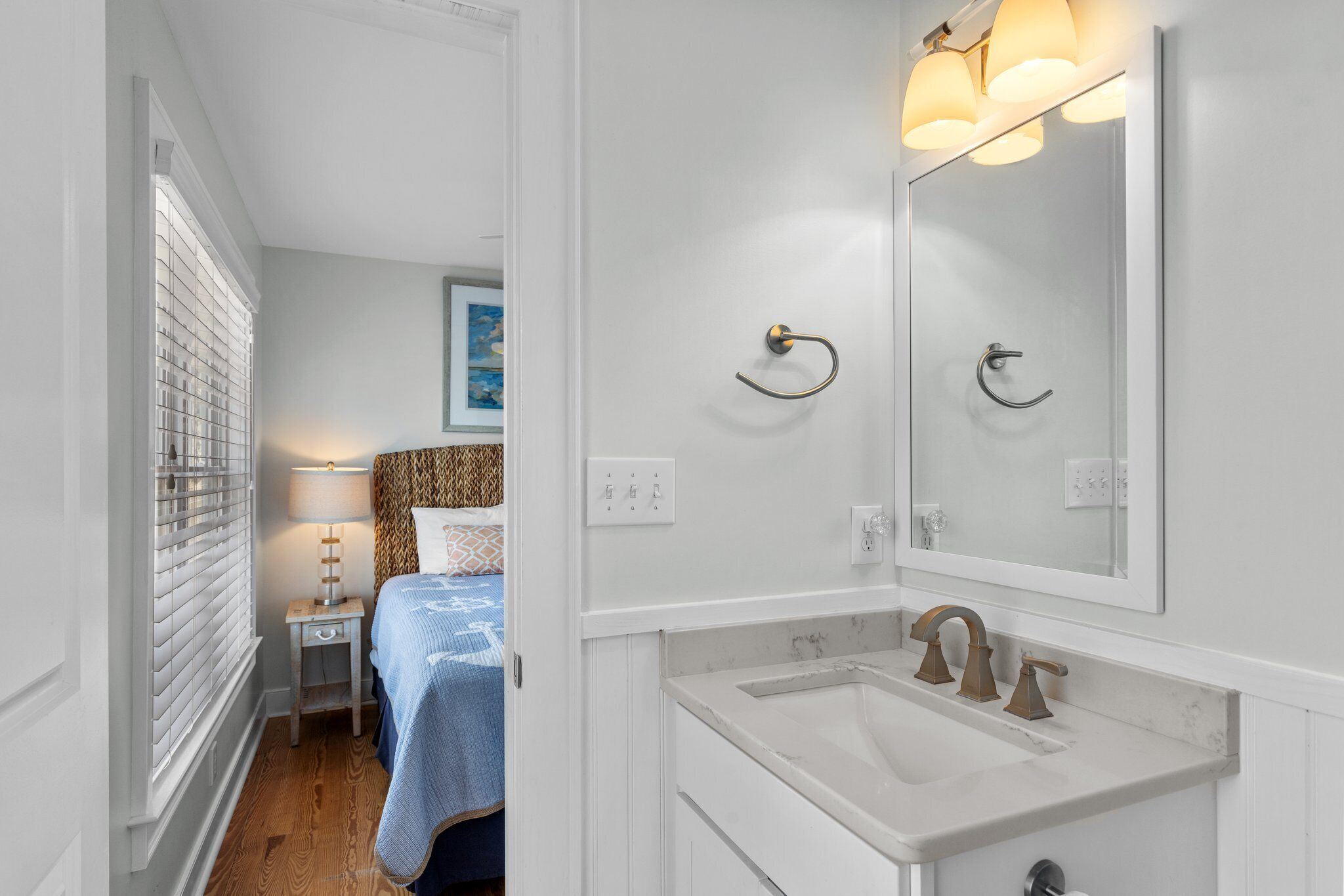 A modern bathroom with a white sink, a mirror, and a towel rack.