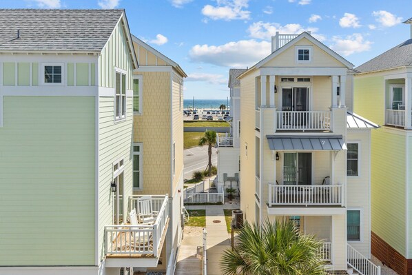 A row of two-story beachfront condominiums with balconies, a parking lot, and a view of the ocean. - Poolside House w/ Ocean Views, Steps from Beach & Restaurants (Atlantic Beach)