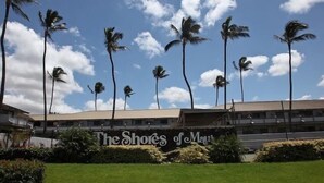 A hotel with a sign reading "The Shores of Maui" and palm trees in the background. - Shores of Maui - Ocean View- Top Floor Unit--Spacious! AC & WiFi (Kihei)
