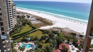 A beachfront hotel with a pool, beach access, and a view of the ocean.