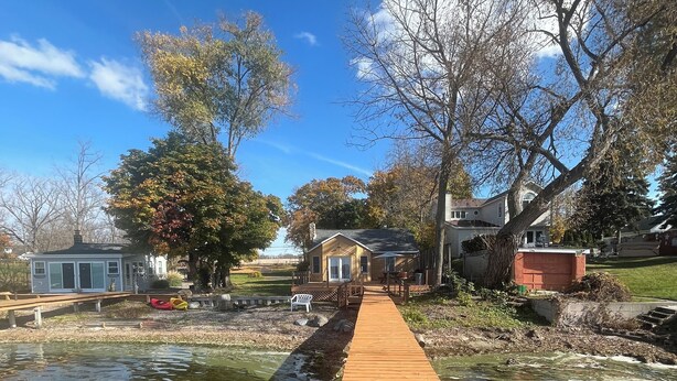 A wooden dock leading to a house with a pond in the foreground. - Lake House on Seneca Lake with Private Dock (Romulus)