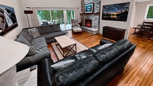 Ein modernes Wohnzimmer mit Kamin, einer Couch, einem Couchtisch und einem Essbereich.