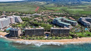 A coastal resort with multiple high-rise buildings, a beach, and a mountainous backdrop.