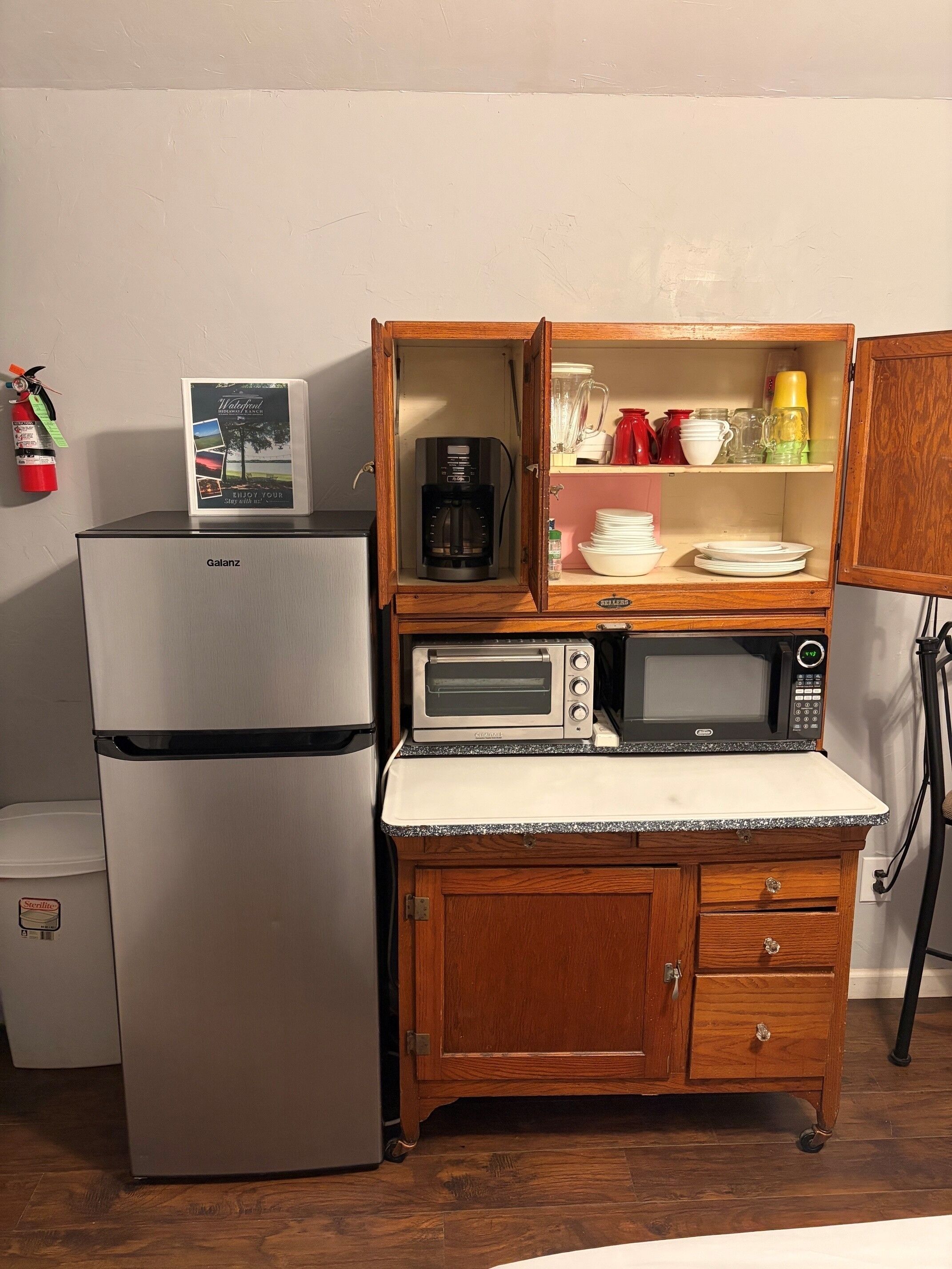Une petite cuisine équipée comprenant un réfrigérateur Galanz, une machine à café, un grille-pain et un four à micro-ondes.