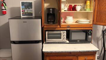 Une petite cuisine équipée comprenant un réfrigérateur Galanz, une machine à café, un grille-pain et un four à micro-ondes.