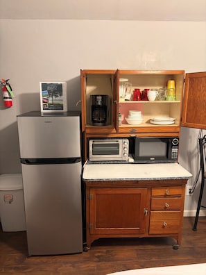 Una cuina compacta amb un frigorífic Galanz, una cafetera, un torradora i un microones.