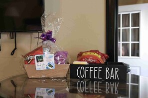 A coffee bar area with a sign, a gift basket, and bags of coffee. - Adventure & Attractions Hub | Ray Roberts Lake, Hiking & Wildlife Watching (Little Elm)