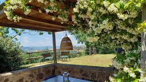 An outdoor patio with a table and chairs, a hanging lantern, and a view of the landscape. - Beautiful and Cosy Countryhouse Overlooking Orvieto (Orvieto)