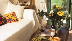 A cozy bedroom with a bed, pillows, a bedside table with a wine glass, a vase with flowers, and a bowl of olives. - Beautiful and Cosy Countryhouse Overlooking Orvieto (Orvieto)