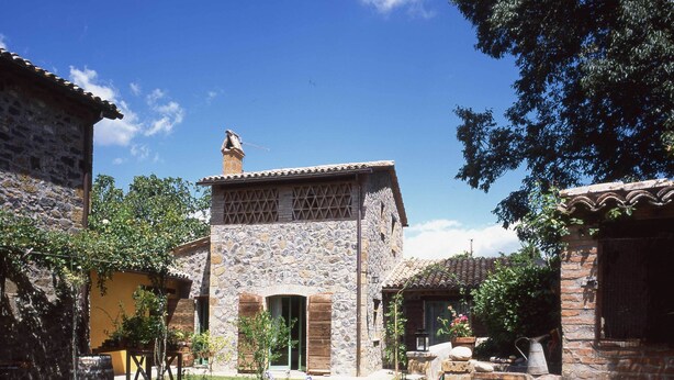 A courtyard with stone buildings, potted plants, and a stone pathway. - Beautiful and Cosy Countryhouse Overlooking Orvieto (Orvieto)