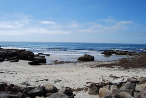 A beach with rocky terrain and the ocean in the background.