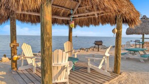 A beachside wooden deck with Adirondack chairs, a thatched-roof gazebo, and a grill. - Key Largo Villa, Kawama P6, 3/3 (Key Largo)