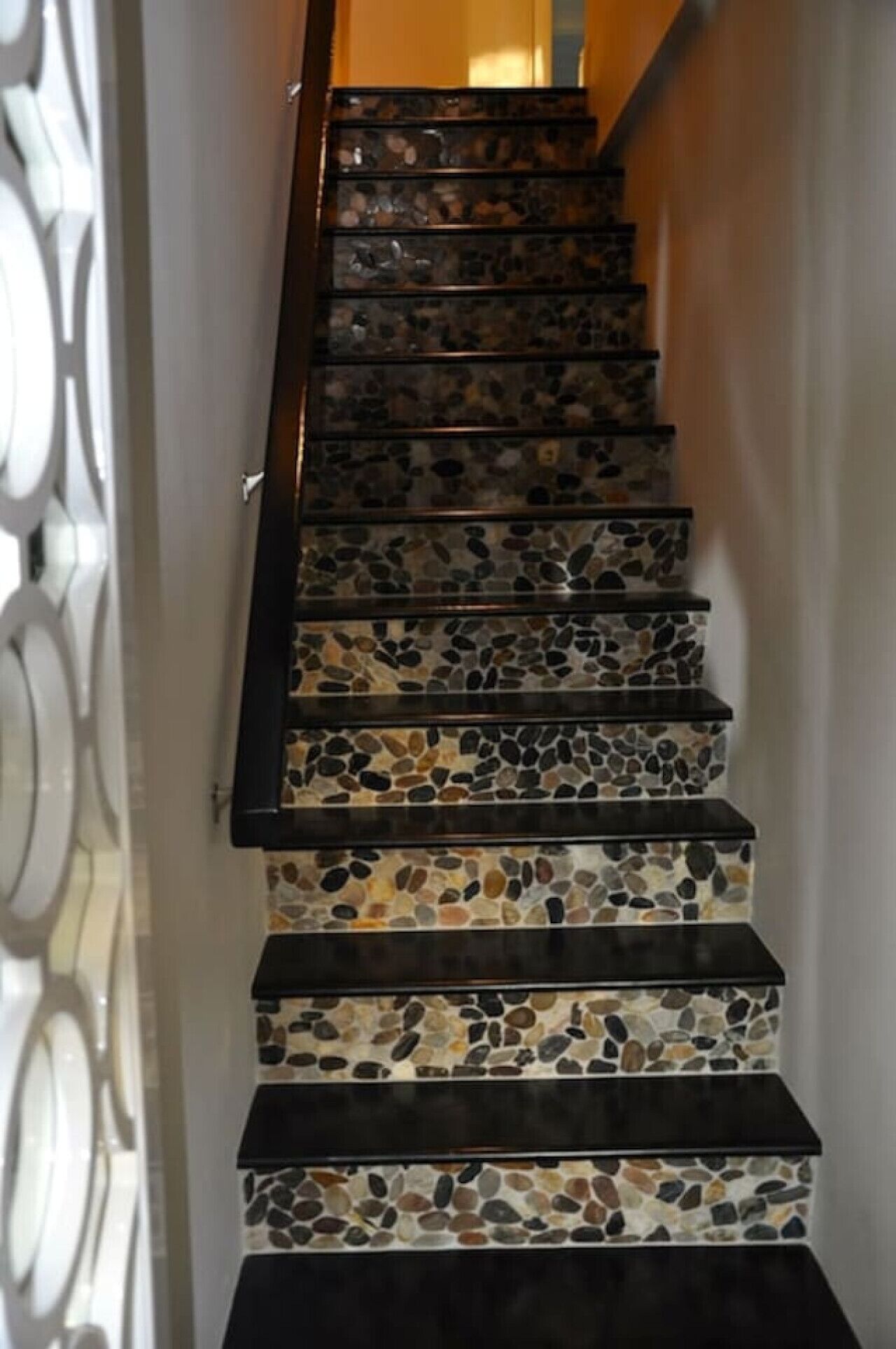 Una scala con gradini in legno scuro e un piano di terrazzo.