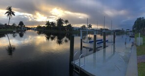 Enjoy serene waterfront views from the dock with a seating area and lush surroundings.