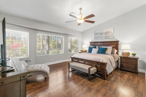 A bedroom with a bed, a desk with a chair, a bench, a nightstand, and a ceiling fan. - Luxurious Family Rental w/ Heated Pool and sport court (Scottsdale)
