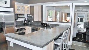 Una cocina moderna con electrodomésticos de acero inoxidable, una isla grande y vistas al exterior.