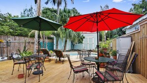 A wooden deck with outdoor furniture, a pool, and a wooden fence.