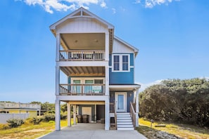A two-story building with a balcony on the upper floor, a front door, and a small porch area.