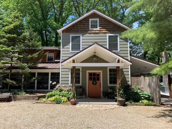 A two-story house with a front porch, a wooden fence, and a gravel driveway. - Goldberry Woods Home on 30 acres-Pool/River/Woods/Trails/Farm. 1 mile to Beach! (Union Pier)