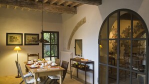 A dining area with a wooden table set for a meal, a lamp, and framed pictures on the wall. - FABULOUS 4BD HOME IN CAPALBIO W/ PRIVATE POOL & GARDEN, MINUTES TO THE BEACH! (capalbio)