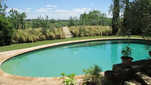 A swimming pool with a stone border, surrounded by grass and trees. - FABULOUS 4BD HOME IN CAPALBIO W/ PRIVATE POOL & GARDEN, MINUTES TO THE BEACH! (capalbio)