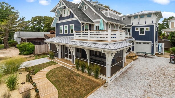 Une maison à deux étages avec un patio couvert et un garage.