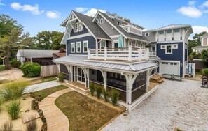 A two-story house with a covered patio and a garage. - Steps to Beach!  California Vibe - Families, Groups, Reunions - Fun Property! (Rehoboth Beach)