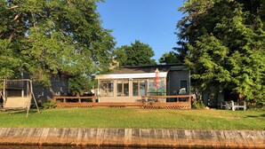 A house with a deck, a swimming pool, and a wooden fence.