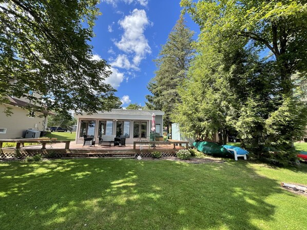 A residential property with a covered patio, outdoor seating, and a well-maintained lawn.
