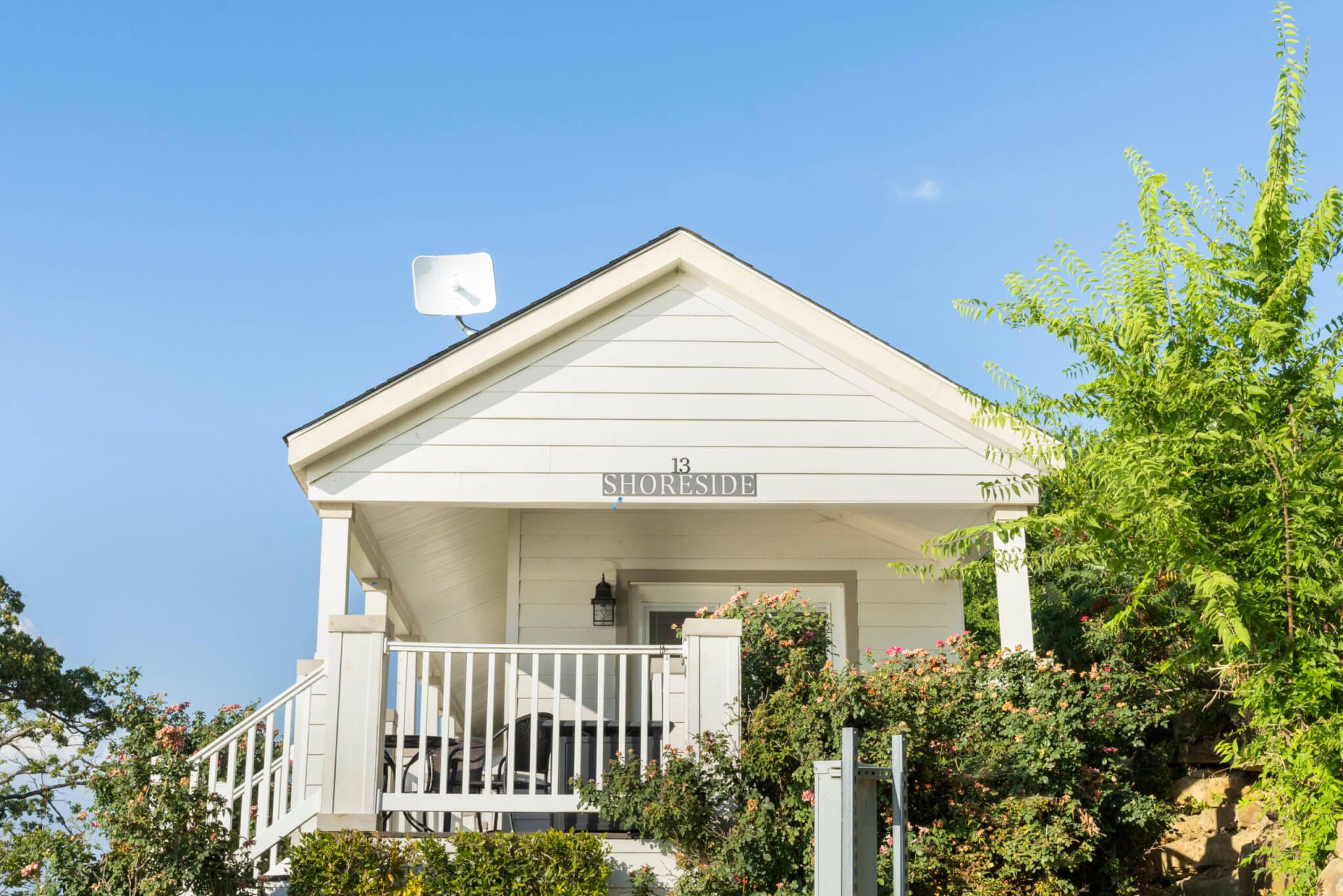 A white building with a sign reading "13 SHORESIDE" and a balcony with railings.