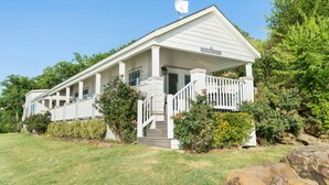 A white building with a covered porch and a flag on top. - Shoreside at CrossTimbers Marina (Sperry)