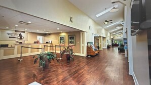 Un hall espacioso con suelo de madera, un mostrador de recepción, plantas en macetas y un cartel de Hilton Head Island Beach & Tennis Resort.