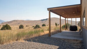 Un espace extérieur abrité offrant une vue sur un paysage vallonné.