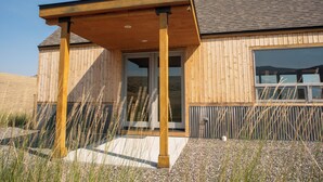 Un bâtiment en bois doté d’une entrée abritée et de grandes fenêtres.