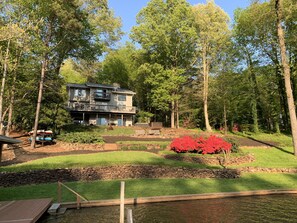 Surrounded by a serene garden with a pond and wooden dock, this property offers a peaceful retreat.