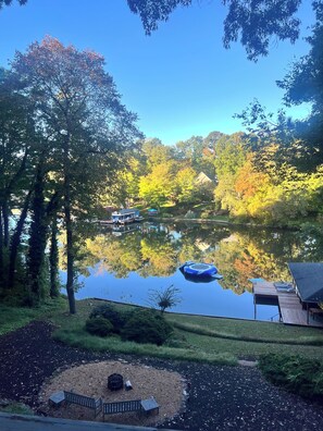 A tranquil lakeside setting with a dock, a small boat, and a gazebo.