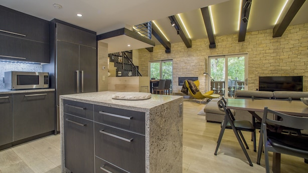 A modern kitchen with a central island, dark cabinetry, and a built-in microwave. - PLATINUM RATED LUXURY CONDO IN VAIL VILLAGE WITH AC AND SKI LOCKER NEXT TO LIFT (Vail)