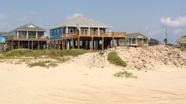 A beachfront property with a wooden deck and a second-story balcony. - Beach Front Home, Huge Deck, Sleeps 12 (Crystal Beach)
