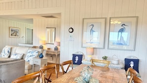 Un espace repas comprenant une table en bois, des chaises et un centre de table décoratif en verre.