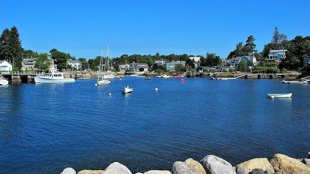 A harbor with boats, a bridge, and houses along the waterfront.