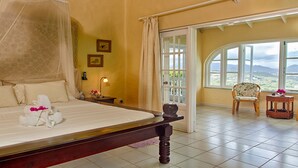 Une chambre à coucher comprenant un lit, une table de chevet, une lampe, un téléphone et une vue sur l’extérieur grâce à une grande fenêtre.