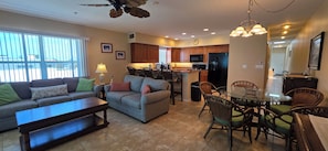 A living room with a sofa, a coffee table, and a dining area with chairs and a table. - Beachfront Bliss: A Guest Favorite for Flip-Flops, Beach Days & Stunning Sunsets (Indian Rocks Beach)
