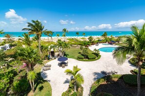 A resort with a pool, palm trees, and a beach view.